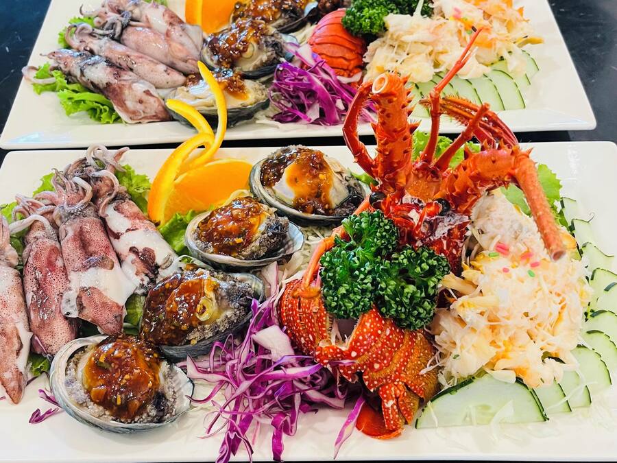 Un plateau de fruits de mer comprenant divers éléments, notamment des calamars, des huîtres et des pinces de crabe.