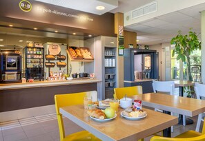 A breakfast buffet with various food items and a coffee machine. - B&B Hotel Salon De Provence (Salon-de-Provence)