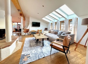 A spacious living room with a sofa, coffee table, and a television.