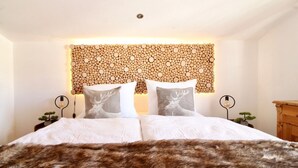 A bed with a fur throw, two bedside tables with lamps, and a wall with a circular pattern.