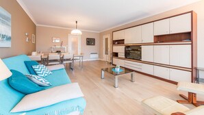 Una sala de estar moderna con un sofá, una mesa de centro y un comedor con sillas y una mesa.