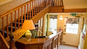 A wooden staircase with a lamp and a vase on the landing. - Monsal Head Hotel (Buxton)