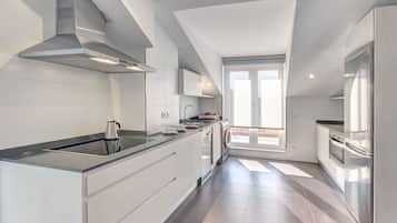 Een koelkast met diepvriezer, een microgolfoven, een oven, een kookplaat
