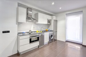 Una cocina moderna con electrodomésticos integrados, lavavajillas y lavadora.