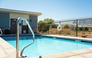 Una piscina al aire libre, sillones reclinables de piscina