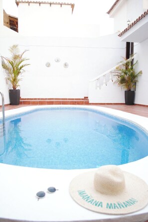 A swimming pool with a white interior, surrounded by white walls and potted plants. - Villa Casa Blanca (Costa Adeje)