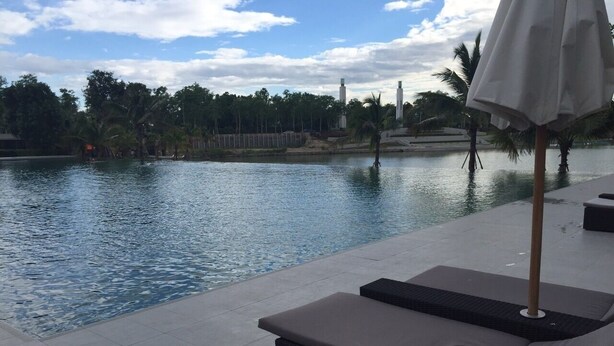 Un espace aménagé au bord de la piscine, avec des chaises longues et un parasol.