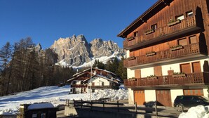 A wooden building with balconies and a mountain backdrop. - Casa Pecol (Cortina d´Ampezzo)