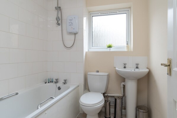Une salle de bain avec une baignoire, des toilettes et un lavabo.