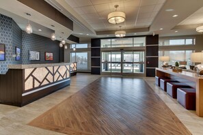 A spacious lobby with a reception desk, wooden flooring, and pendant lighting. - Drury Inn & Suites Columbus Polaris (Columbus)