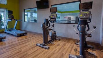 A gym with treadmills, stationary bikes, and elliptical machines.