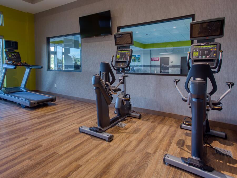 A gym with treadmills, stationary bikes, and elliptical machines.