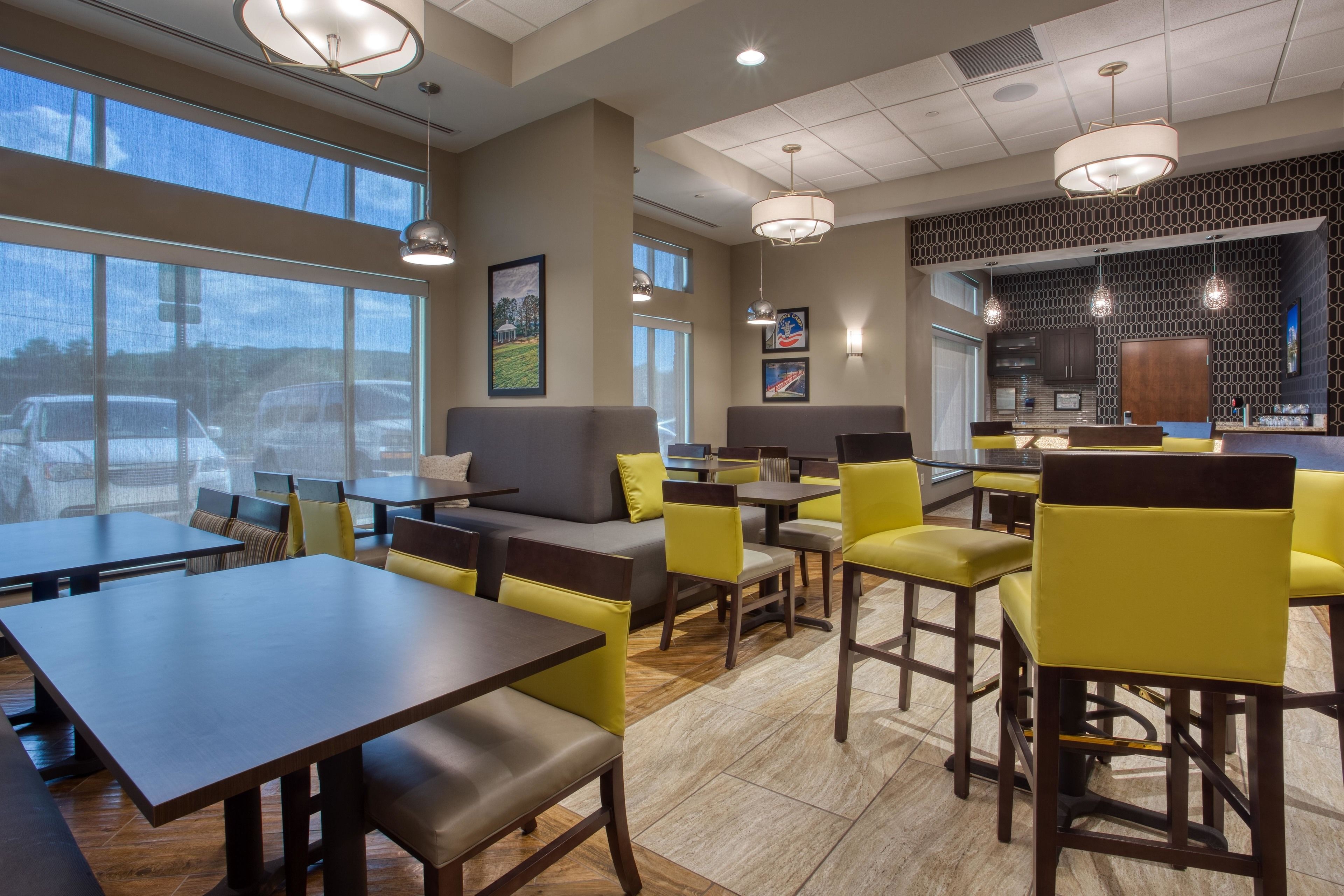 A modern restaurant with high ceilings, large windows, and a mix of seating options including tables and booths.
