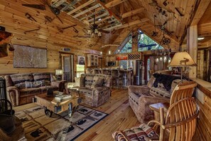 Ein rustikales Blockhaus-Interieur mit Holzwänden, einer Essecke und einer Bar.