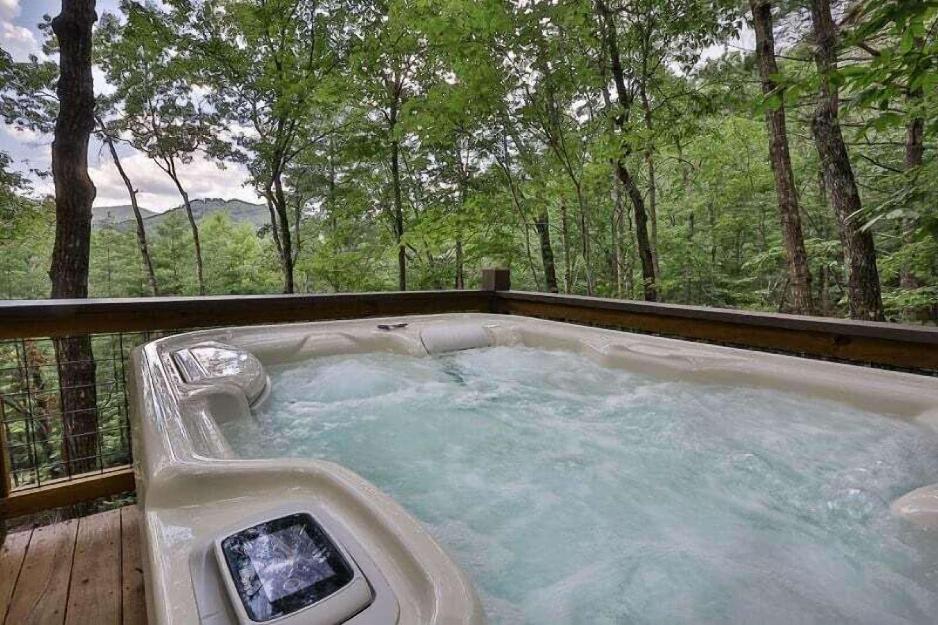 Un jacuzzi rodeado de árboles en una zona boscosa.