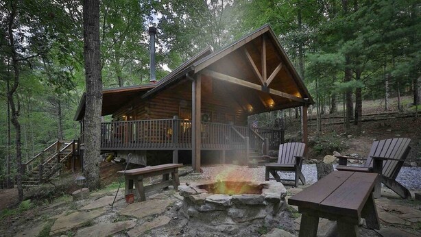 A cabin with a stone fire pit, wooden deck, and outdoor seating. - Aska Retreat | Blue Ridge, GA (Cherry Log)