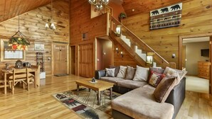 A wooden interior with a sofa, coffee table, and a staircase. - Mountain Lake Escape | Ellijay, GA (Ellijay)