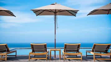 Piscine couverte, piscine extérieure, parasols de plage, chaises longues