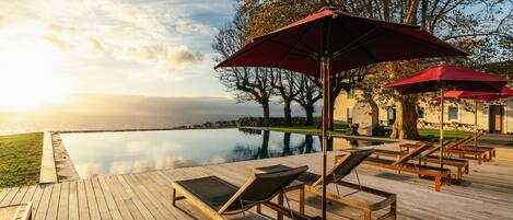 Piscine couverte, piscine extérieure, parasols de plage, chaises longues