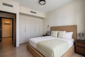 A hotel room with a large bed, a wardrobe, a bedside table with a lamp, and a wall-mounted light fixture. - 4 Px partial sea view, - Rent.Apart.Hollywood (Hollywood)