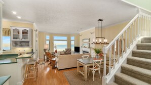 A spacious living area with a kitchen, a dining table, and a staircase.