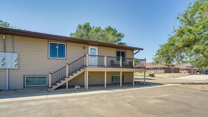A two-story building with a balcony, a staircase, and a covered entryway. - Roosevelt Suite of Dakota Place Lodge in Medora! (Medora)