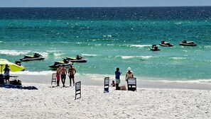 A beach with jet skis, a parasail sign, and people on the sand. - Ocean Sky #1604 Closest Beach Access 2-Bd 2-Bath 2nd Floor (Destin)