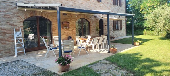 A patio with a table and chairs, a ladder, and potted plants. - Casale Caldarette historic exclusive country house (Ponte Ete-Caldarette)