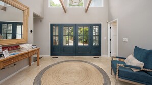 A spacious entryway with a dark blue door, a wooden bench, a blue sofa, and a large mirror. - 67 Plantation Dr - Golf Paradise, Harbour Town 8th Green and 9th Tee (Hilton Head Island)