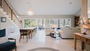 A spacious living area with a dining table, sofas, and a staircase. - 67 Plantation Dr - Golf Paradise, Harbour Town 8th Green and 9th Tee (Hilton Head Island)