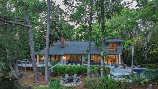 A two-story house with a deck, surrounded by trees and a small pond. - 67 Plantation Dr - Golf Paradise, Harbour Town 8th Green and 9th Tee (Hilton Head Island)