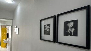 A hallway with two framed black and white floral artworks on the wall. - Rio Habitat - Nsa Sra Apartaments (Rio de Janeiro)