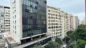 A modern high-rise building with a glass facade and multiple air conditioning units. - Rio Habitat - Nsa Sra Apartaments (Rio de Janeiro)