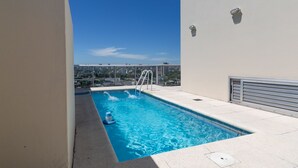 Une piscine sur le toit offrant une vue sur le paysage urbain.