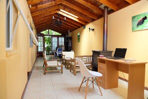 A cozy room with wooden furniture, a desk with a laptop, and a bear painting on the wall. - Casa Suiza - Hostel (Santa Cruz)