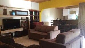 A living room with a flat-screen TV, a sofa, and a coffee table. - Casa Sítio Mairiporã (Mairipora)