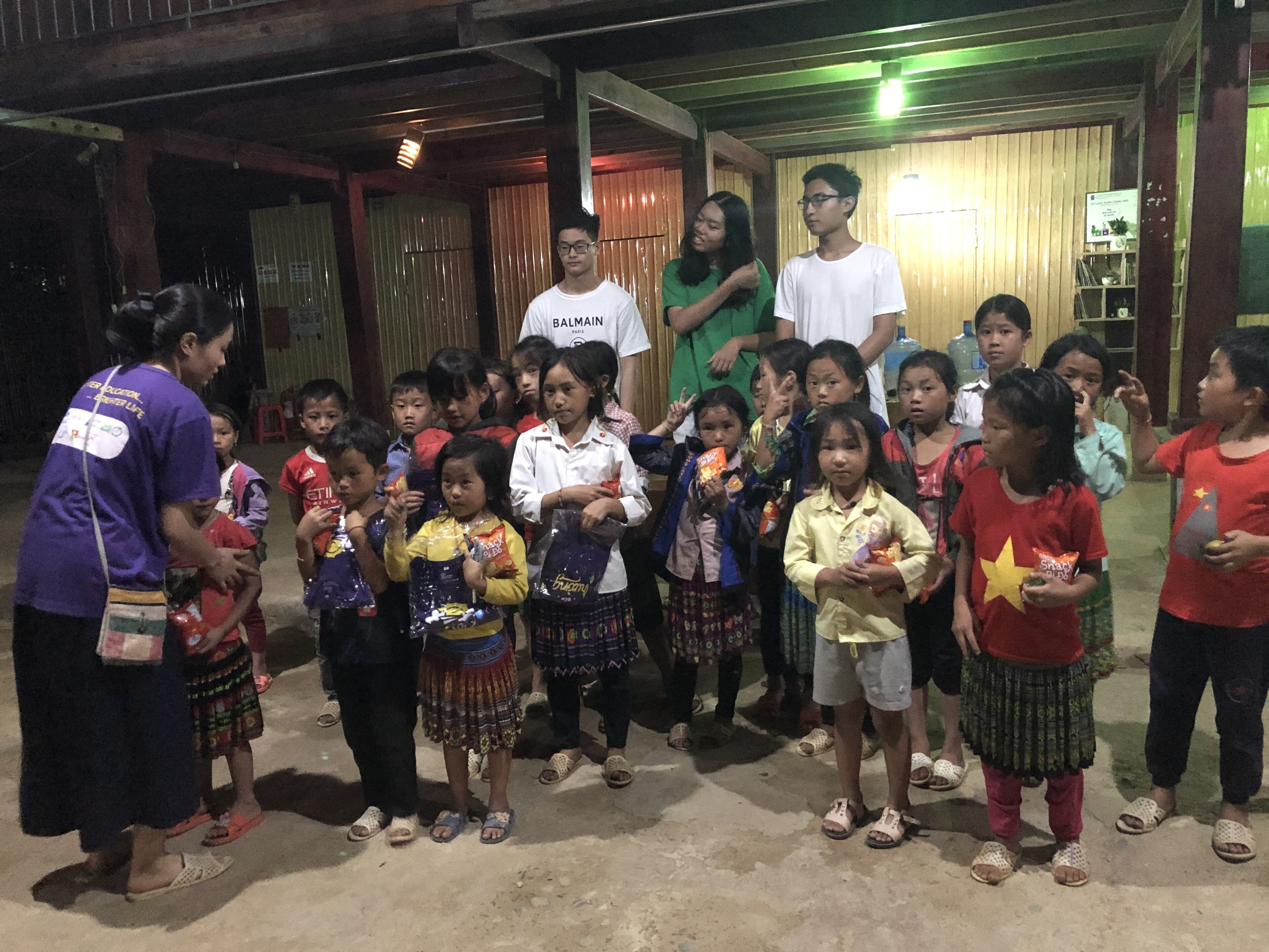 Un groupe d’enfants et d’adultes s’est réuni à l’intérieur, certains tenant des collations à la main.