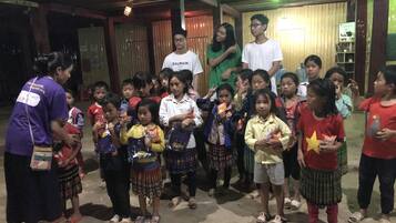 Un groupe d’enfants et d’adultes s’est réuni à l’intérieur, certains tenant des collations à la main.
