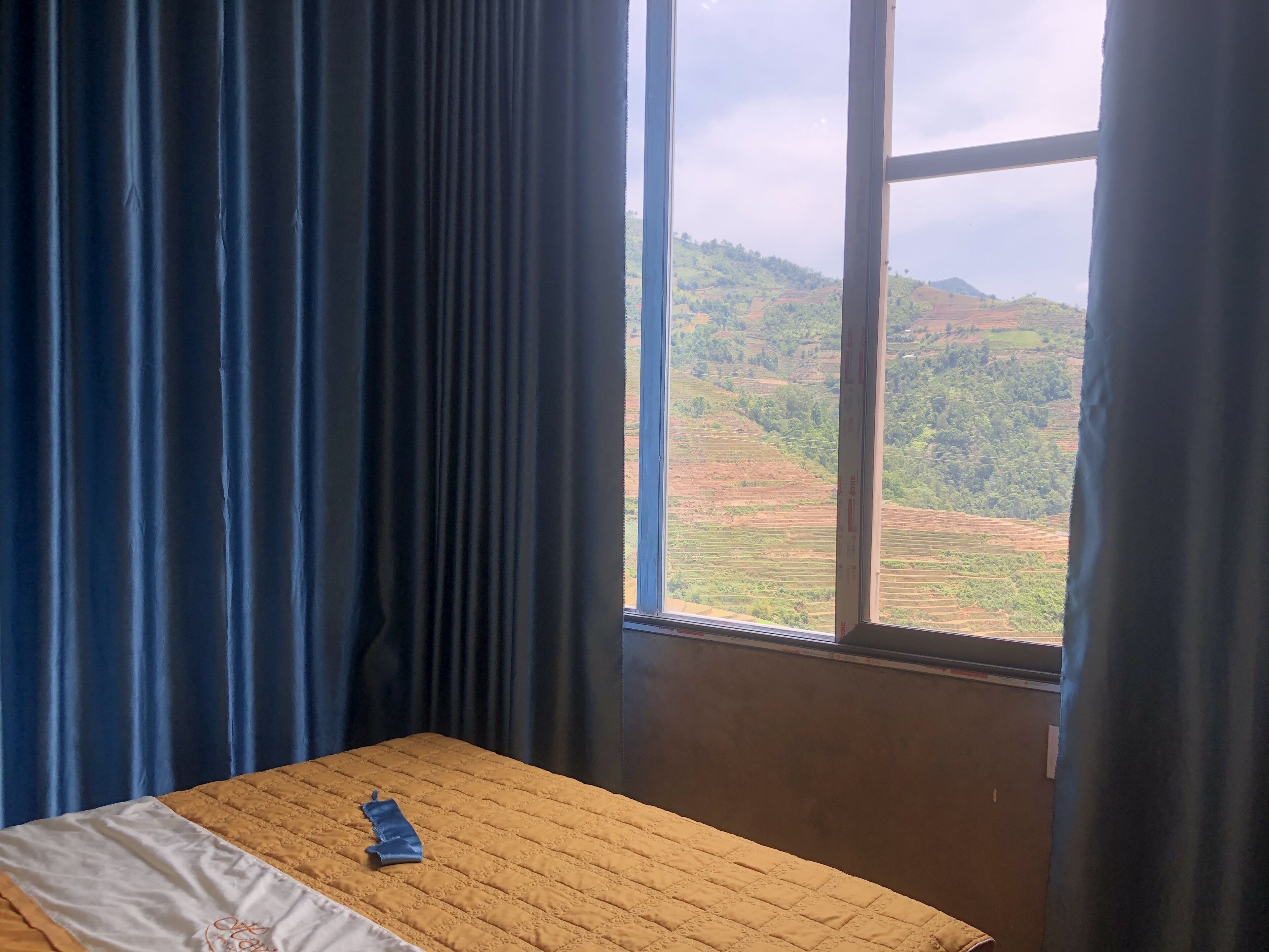 A room with a bed, a window, and curtains.