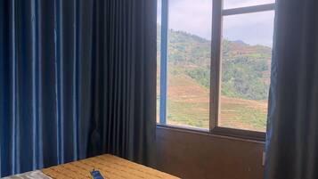 A room with a bed, a window, and curtains.