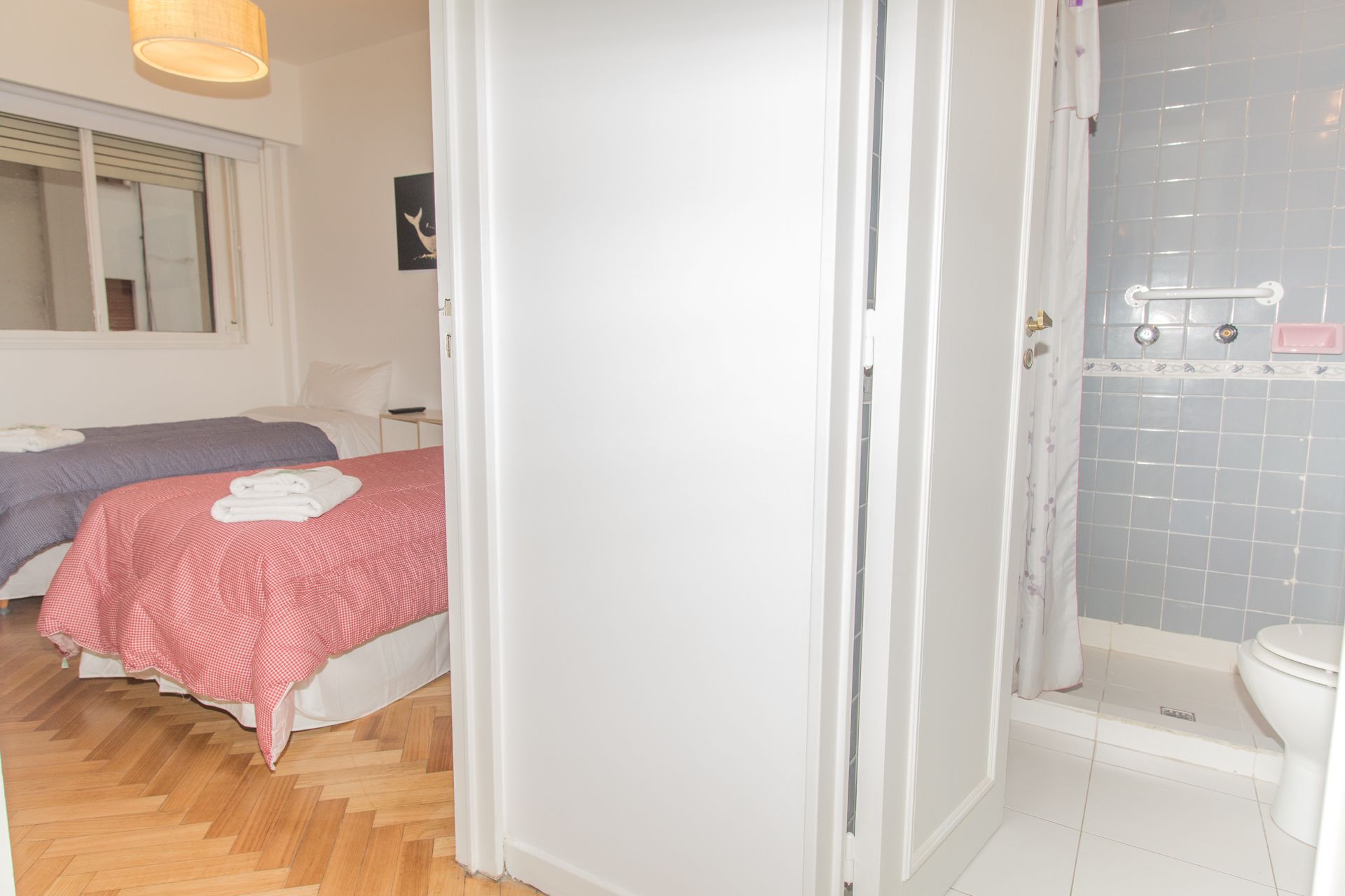 Een hotelkamer met twee bedden, een douche en toilet.