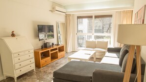 A living room with a sofa, a coffee table, a TV, and a cabinet. - Austria apartment by Be Local Argentina (Buenos Aires)