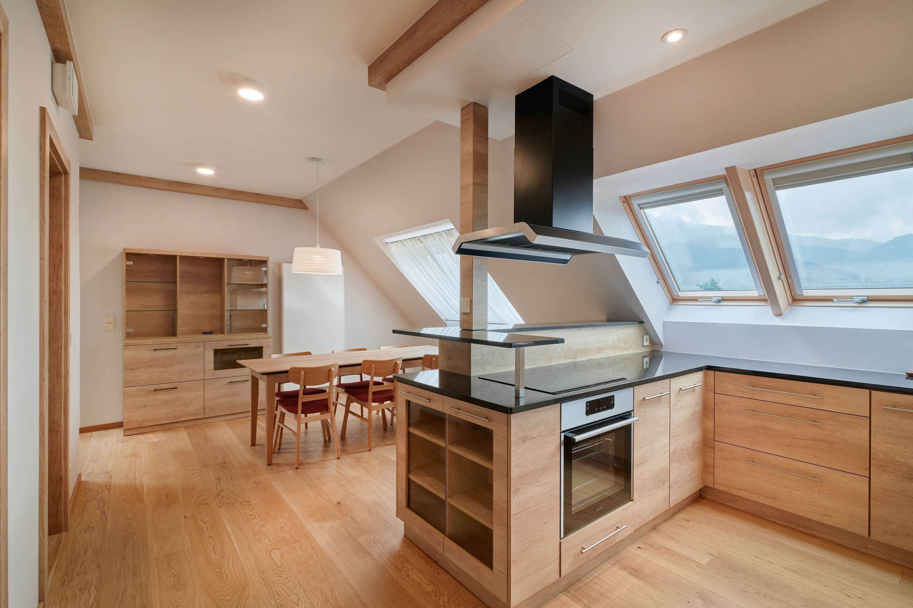 A modern kitchen with wooden cabinets, a glass island, and a built-in oven.