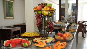 A buffet with various fruits and vegetables, including watermelon, papaya, and apples. - Ouro Cerrado Palace Hotel (Patrocinio)