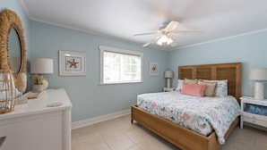 A bedroom with a bed, a ceiling fan, a dresser, and a window. - Sea Spray 2: *Pet-friendly *Steps to the beach *Close to shops, restaurants (Anna Maria)