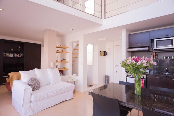 Un apartamento moderno con sala de estar, cocina y comedor.