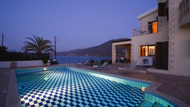 A swimming pool with a checkered pattern, lounge chairs, and a view of the sea and mountains. - Brand New Villa with Private Pool and Panoramic Mountains and Sea Views (Paphos)