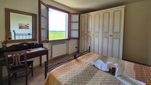Una camera da letto con un letto, una scrivania, una sedia, una finestra e un armadio.