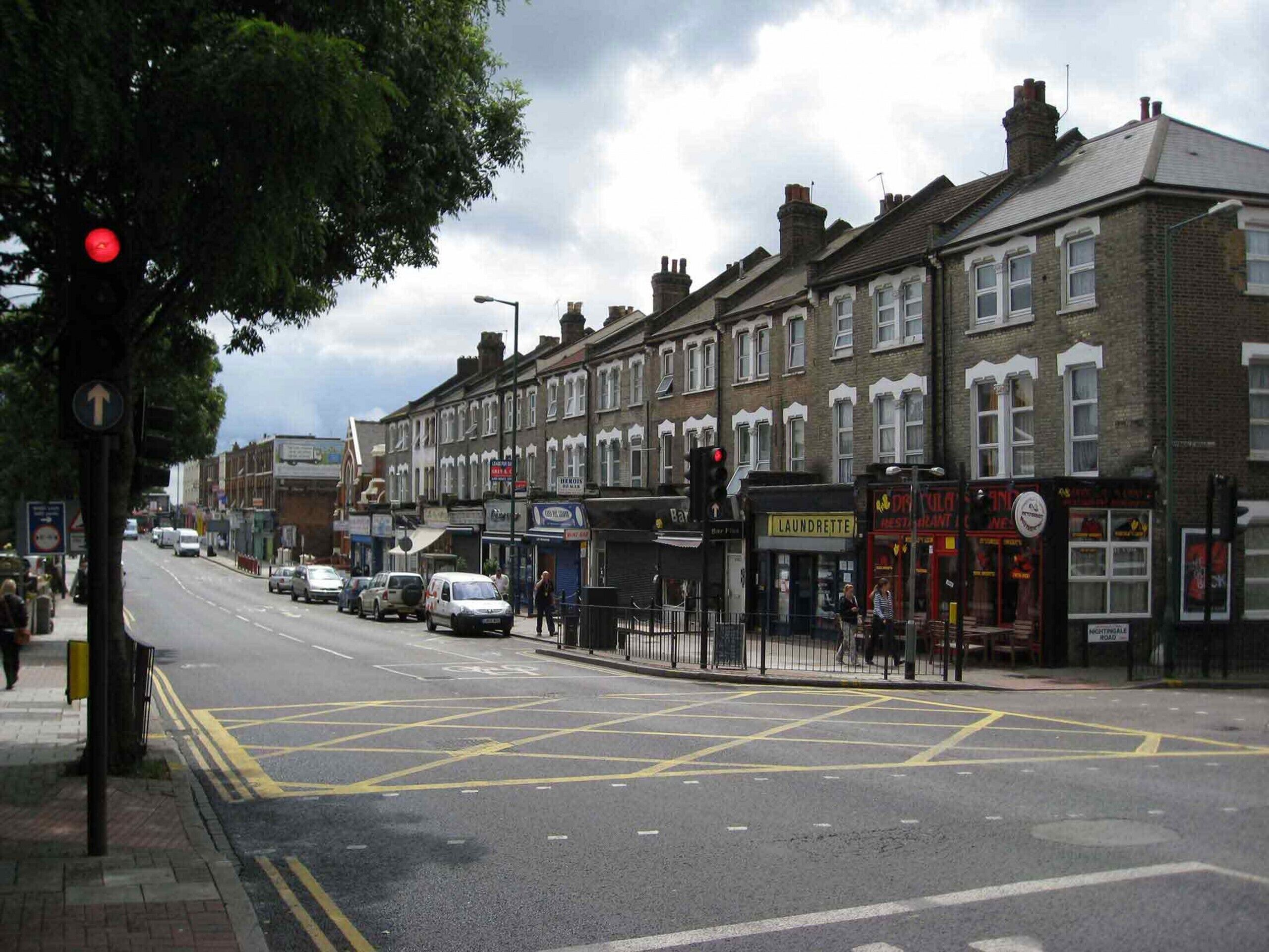 A street view with a row of terraced houses, a laundrette, and a restaurant.