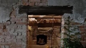A small, enclosed brick structure with a fireplace, possibly a fireplace room or a small lounge area.
